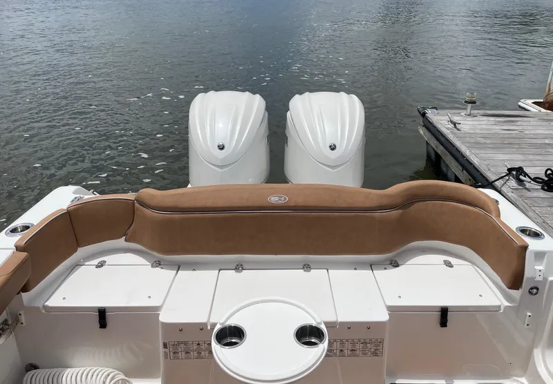 Slide: The Image of 2024 Sea Hunt Ultra 305 SE boat with twin engines and tan seating at dock. - 38