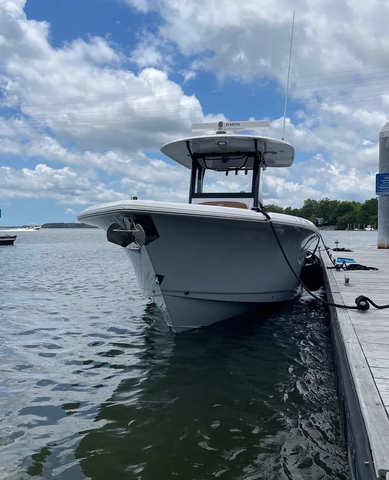Slide: The Image of 2024 Sea Hunt Ultra 305 SE boat docked on a sunny day. - 4