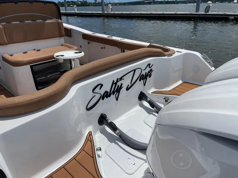 Slide: The Image of 2024 Sea Hunt Ultra 305 SE boat with "Salty Days" text, docked by the water. - 40