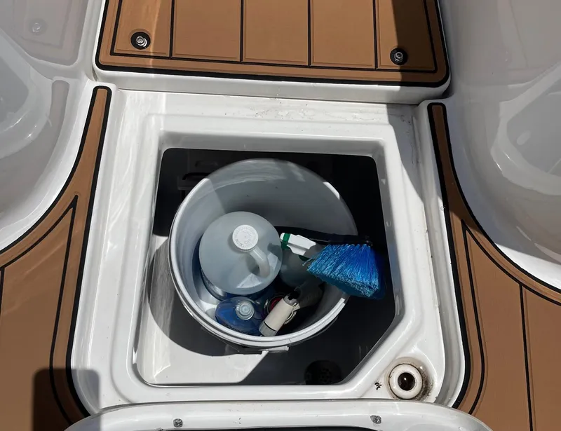 Slide: The Image of Storage compartment on 2024 Sea Hunt Ultra 305 SE boat with cleaning supplies. - 42