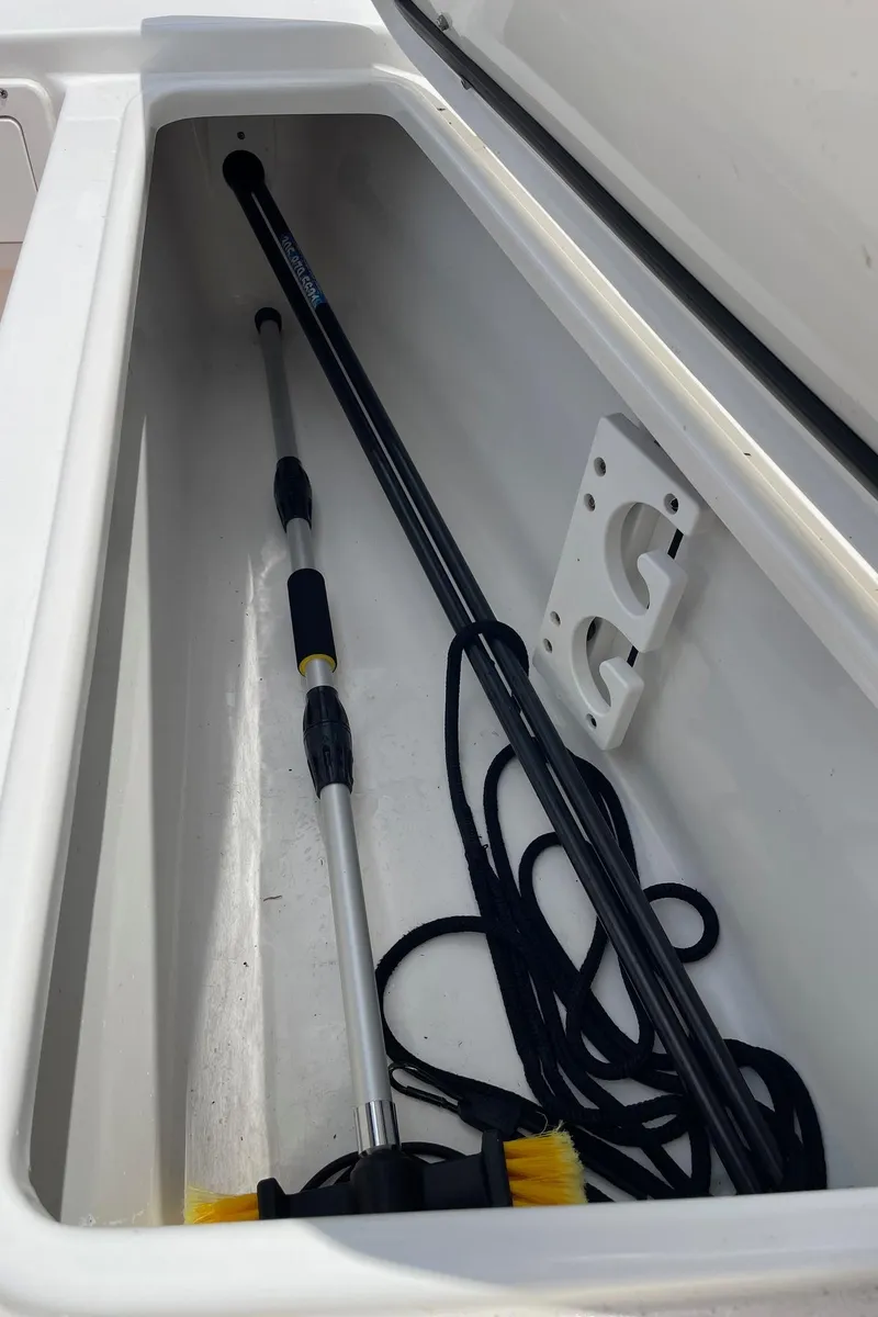 Slide: The Image of Storage compartment in 2024 Sea Hunt Ultra 305 SE boat with cleaning tools. - 46