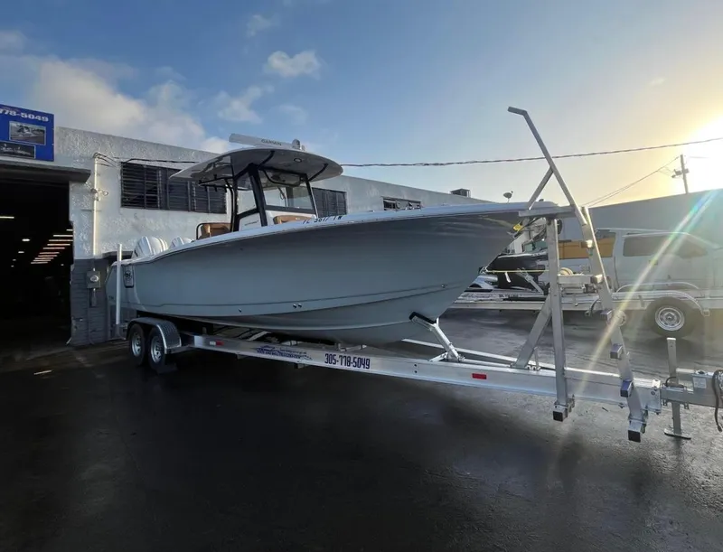 Slide: The Image of 2024 Sea Hunt Ultra 305 SE boat on trailer outside a building at sunset. - 7