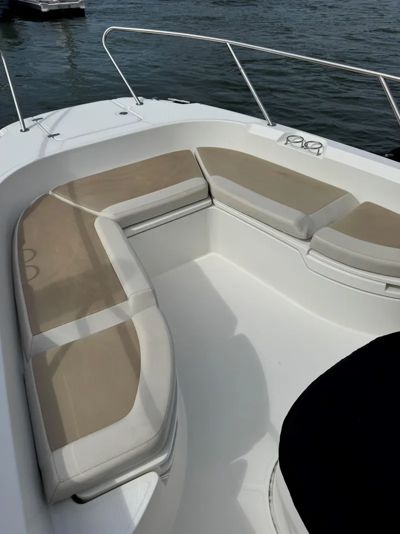 Slide: The Image of 2017 Boston Whaler 270 Dauntless boat with cushioned seating, docked on calm water. - 12