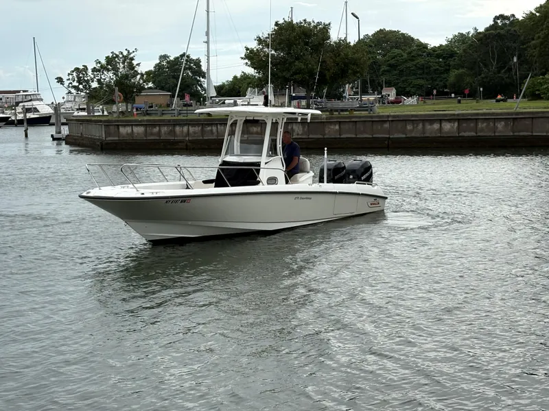 Slide: The Image of 2017 Boston Whaler 270 Dauntless boat cruising in a marina setting. - 14