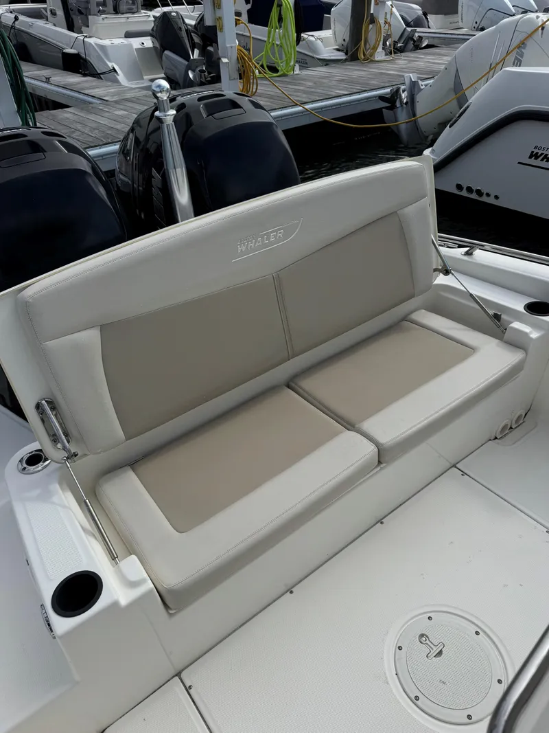 Slide: The Image of 2017 Boston Whaler 270 Dauntless boat with cushioned seating and dual engines at dock. - 4