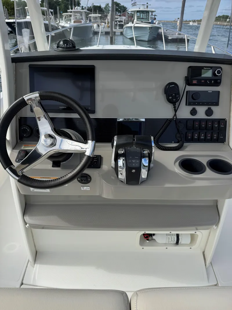 Slide: The Image of 2017 Boston Whaler 270 Dauntless helm with steering wheel, controls, and navigation equipment. - 8