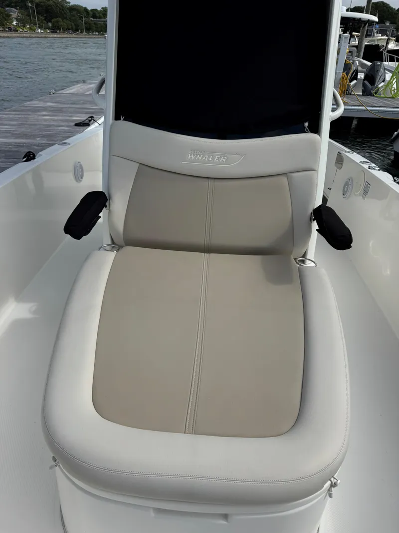 Slide: The Image of 2017 Boston Whaler 270 Dauntless boat seat, beige and white upholstery, dockside view. - 9