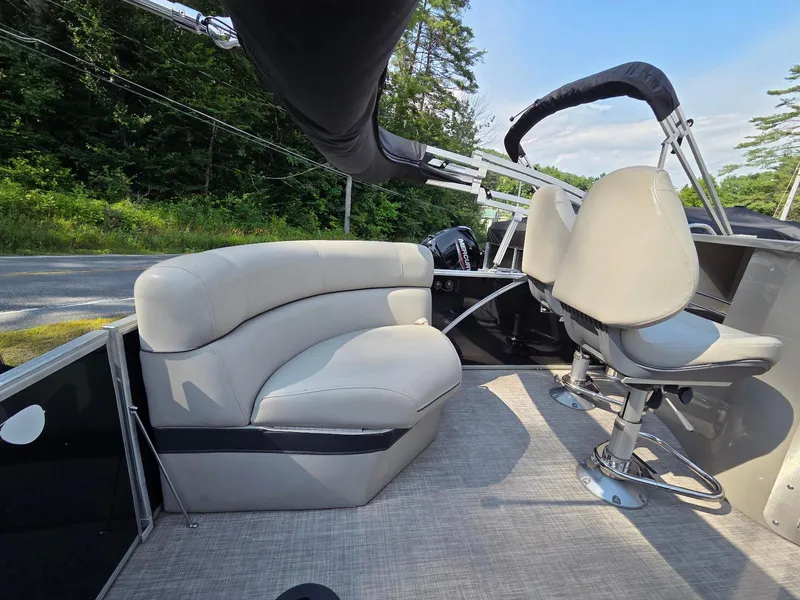 Slide: The Image of 2018 South Bay 523 boat interior with plush seating and modern helm, surrounded by lush greenery. - 14