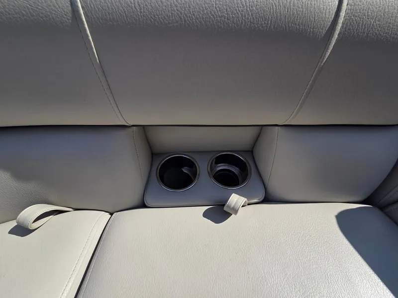 Slide: The Image of 2018 South Bay 523 boat seat with built-in cup holders, featuring light gray upholstery. - 19