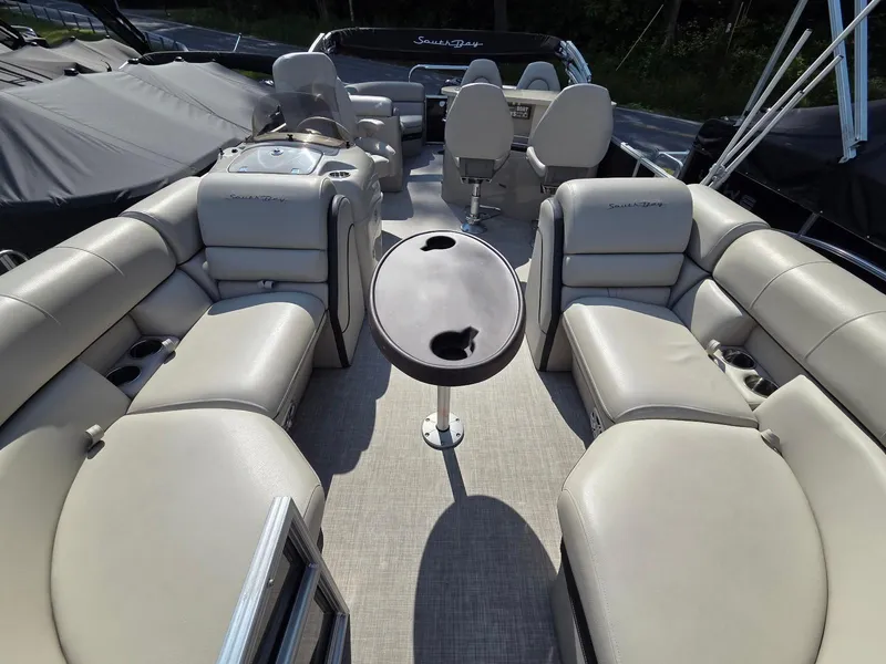 Slide: The Image of Luxurious 2018 South Bay 523 pontoon boat interior with beige seating and central table. - 4