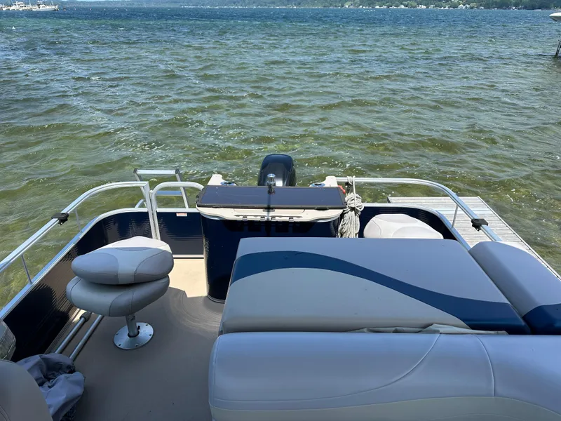 Slide: The Image of 2012 Bennington 2275 GS pontoon boat on a lake, featuring comfortable seating and scenic water view. - 11