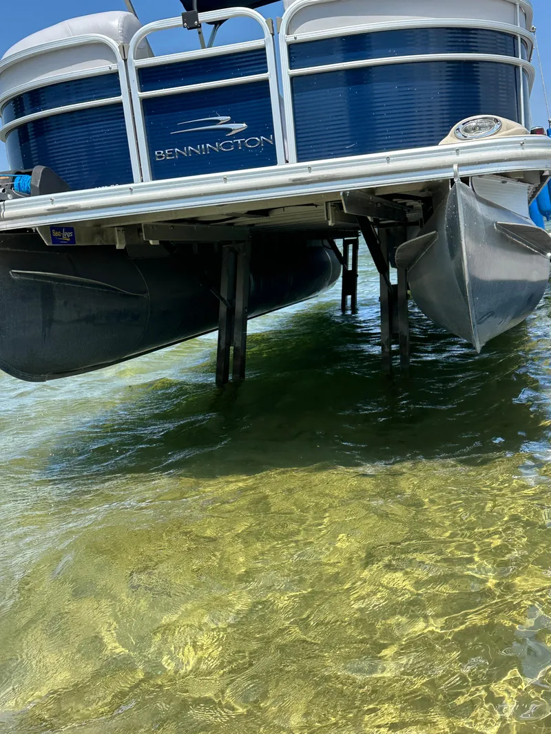 Slide: The Image of 2012 Bennington 2275 GS pontoon boat in shallow water, showcasing its hull and pontoons. - 7