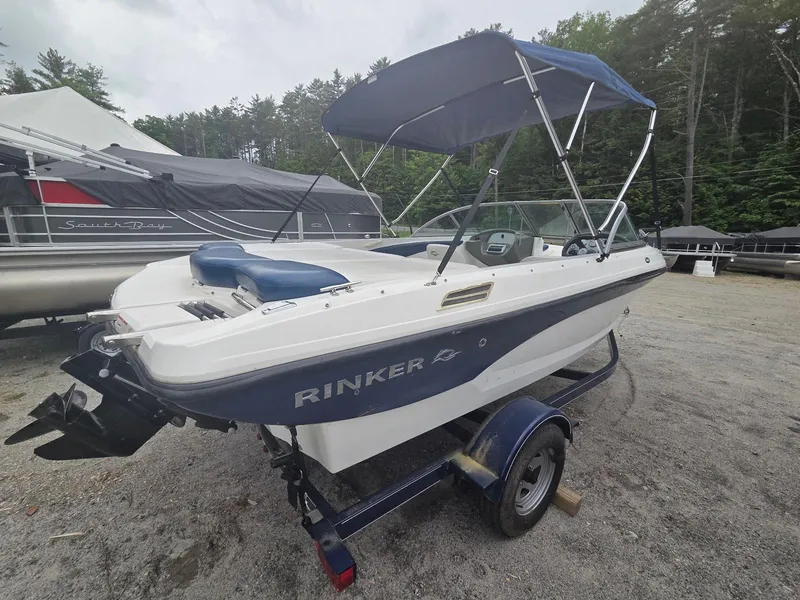 Slide: The Image of 2013 Rinker 186 Captiva boat with blue canopy on trailer, parked outdoors. - 3