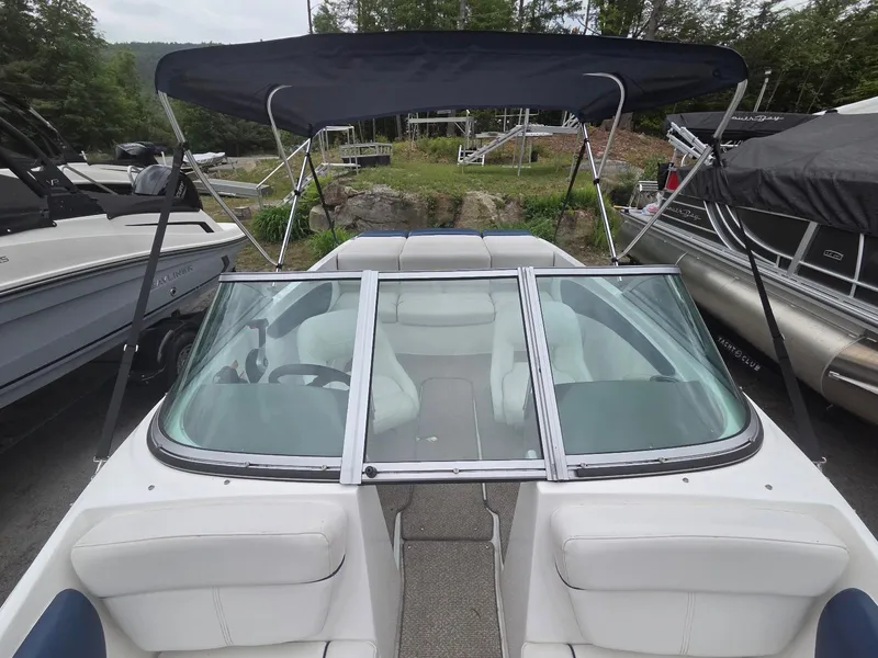 Slide: The Image of 2013 Rinker 186 Captiva boat with canopy and windshield, docked outdoors. - 8
