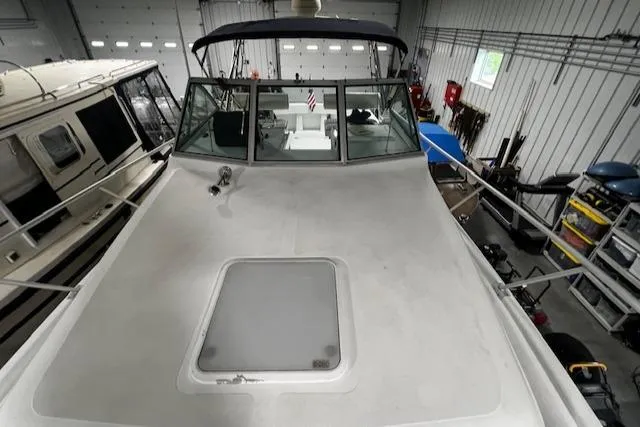 Slide: The Image of 1999 Mainship Pilot 30 Softtop Cruiser in a storage facility, viewed from the bow. - 19