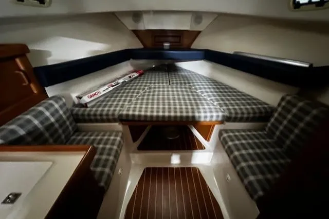 Slide: The Image of 1999 Mainship Pilot 30 Softtop Cruiser interior with plaid seating and wood accents. - 2