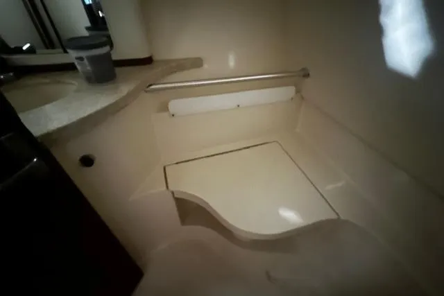 Slide: The Image of 1999 Mainship Pilot 30 Softtop Cruiser bathroom with sink and shower area. - 5