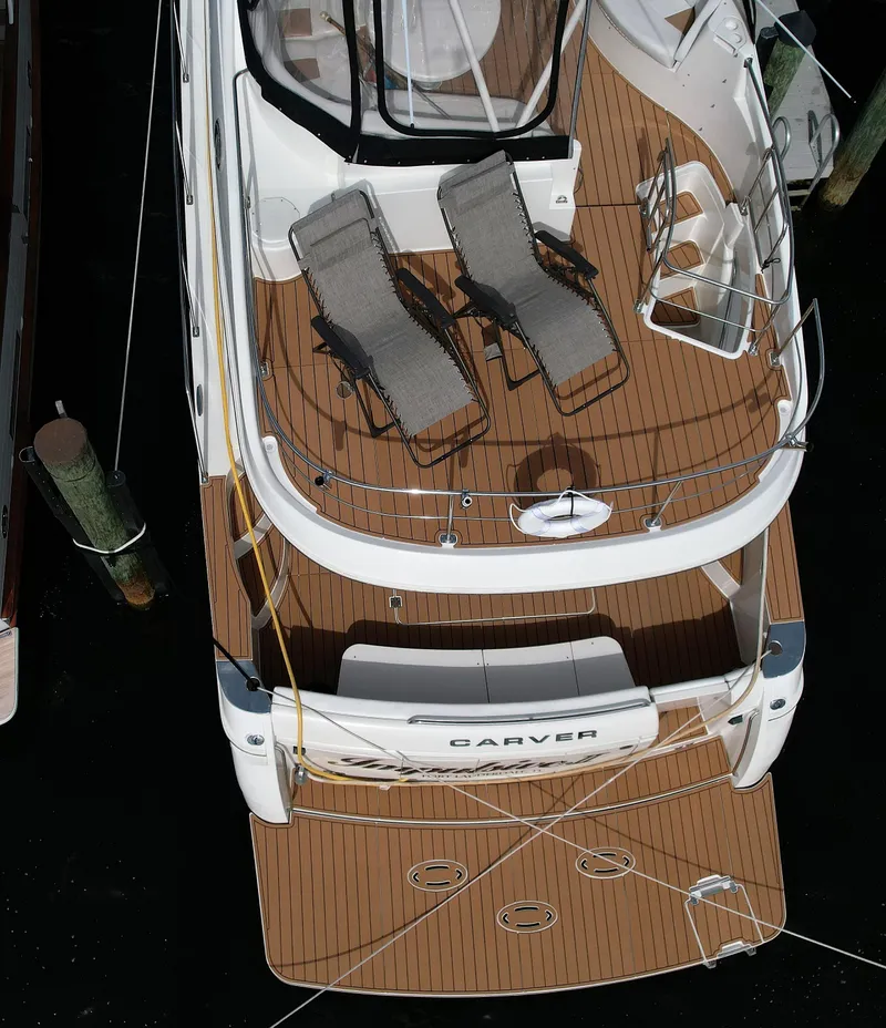 Slide: The Image of 2006 Carver 56 Voyager yacht with deck chairs, docked. - 19