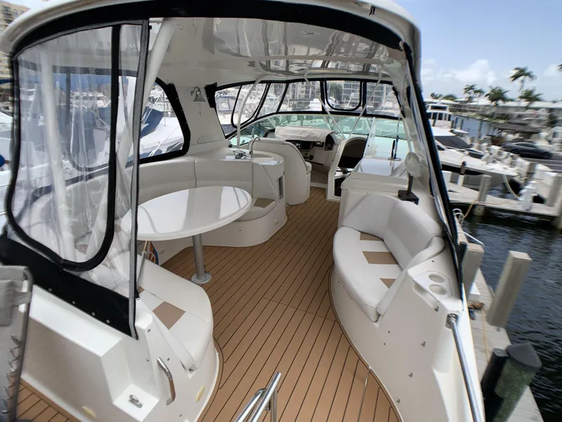 Slide: The Image of 2006 Carver 56 Voyager yacht interior with seating and table, docked at marina. - 16