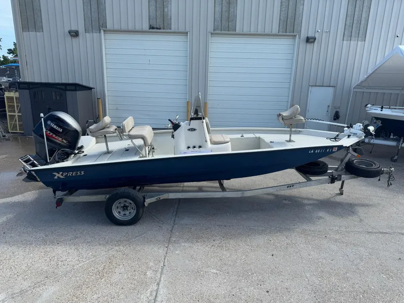 Slide: The Image of 2017 Xpress H20B boat on trailer, parked outside a building. - 5