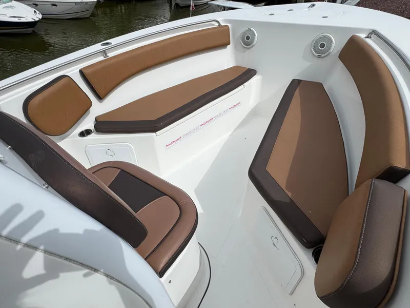Slide: The Image of 2017 Tidewater 230 CC Adventure boat interior with brown cushioned seating. - 13