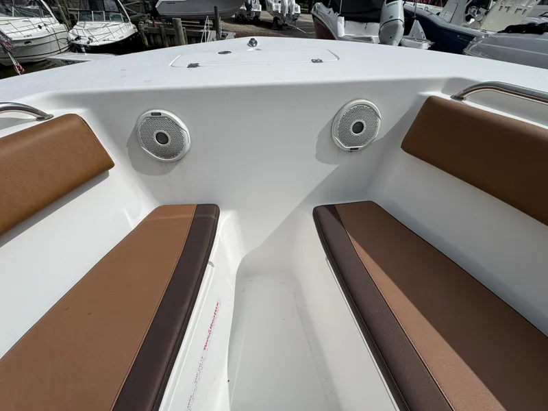 Slide: The Image of 2017 Tidewater 230 CC Adventure boat interior with brown seating and speakers. - 16