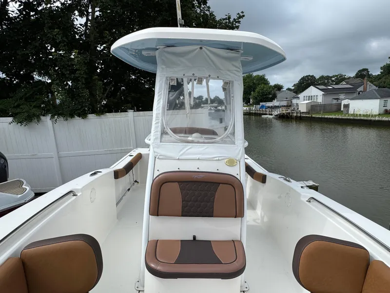 Slide: The Image of 2017 Tidewater 230 CC Adventure boat with brown seating, docked by a canal. - 18