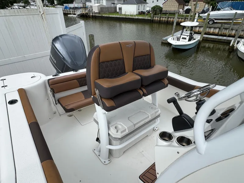 Slide: The Image of 2017 Tidewater 230 CC Adventure boat interior with brown seating and steering console. - 19