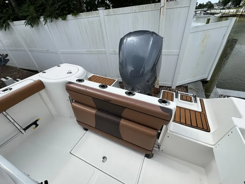 Slide: The Image of 2017 Tidewater 230 CC Adventure boat interior with brown seating and outboard motor. - 2
