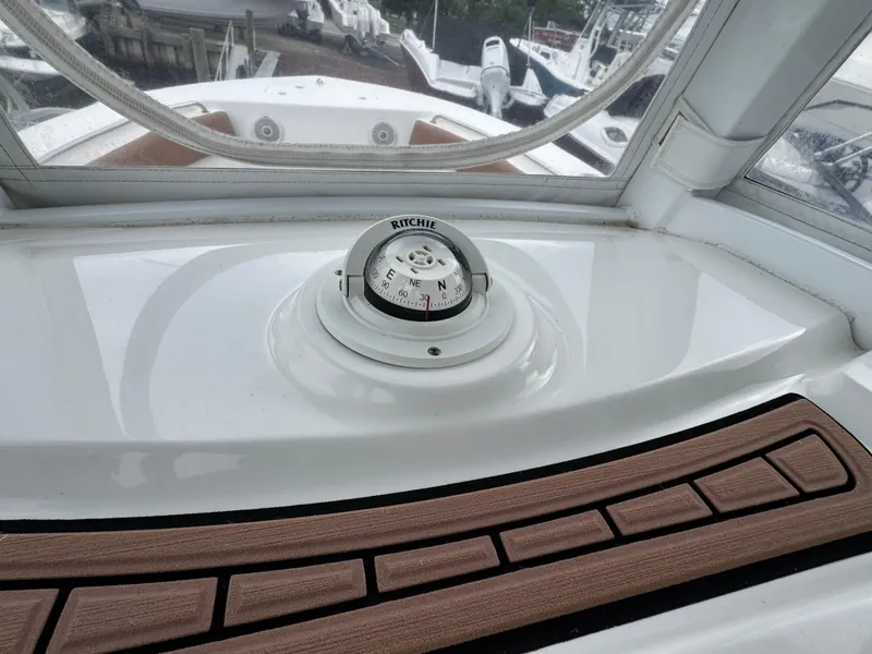 Slide: The Image of Compass on 2017 Tidewater 230 CC Adventure boat dashboard, featuring wood accents and clear windows. - 7