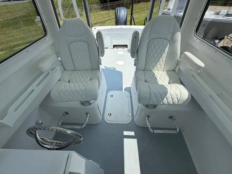 Slide: The Image of 2026 Steiger Craft 255 Miami boat interior with white quilted seats and steering wheel. - 11
