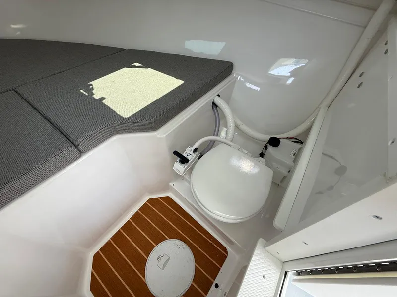 Slide: The Image of 2026 Steiger Craft 255 Miami cabin interior with toilet and cushioned seating. - 13