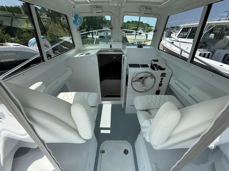 Slide: The Image of Interior of 2026 Steiger Craft 255 Miami boat with white seating and steering wheel. - 9