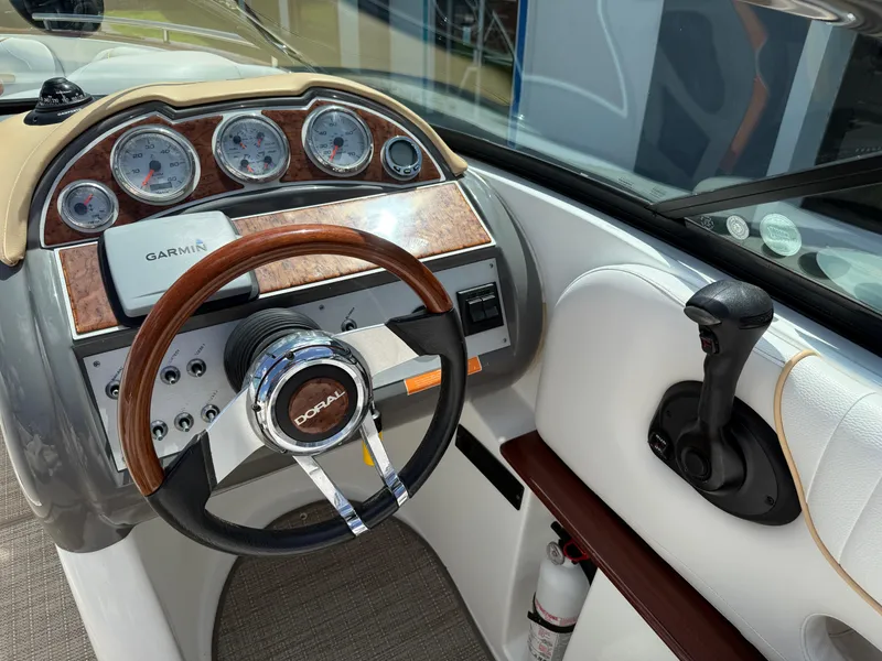 Slide: The Image of 2008 Doral 265 Elite Bowrider dashboard with Garmin navigation and wood-accented steering wheel. - 11
