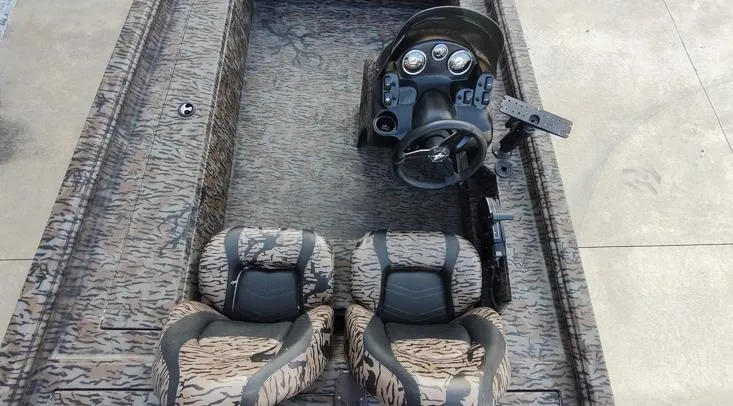 Slide: The Image of 2023 Xpress XP180 boat interior with camouflage seats and steering console. - 8
