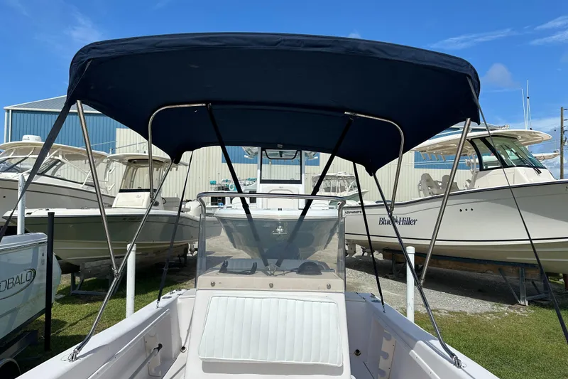 Slide: The Image of 1996 Grady-White Spirit 175 boat with canopy, docked among other boats. - 15