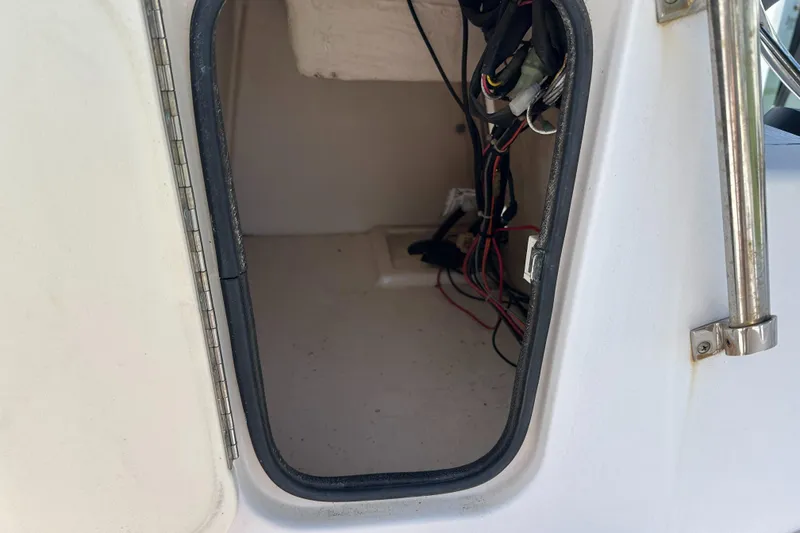 Slide: The Image of Open storage compartment with wiring inside a 1996 Grady-White Spirit 175 boat. - 26