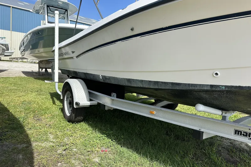 Slide: The Image of 1996 Grady-White Spirit 175 boat on trailer, parked on grass near a blue building. - 4