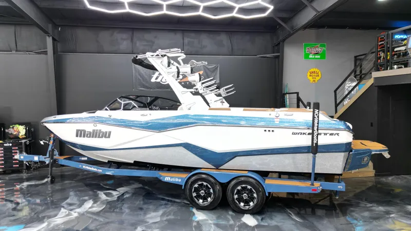 Slide: The Image of 2022 Malibu Wakesetter 25 LSV boat on trailer in showroom. - 2