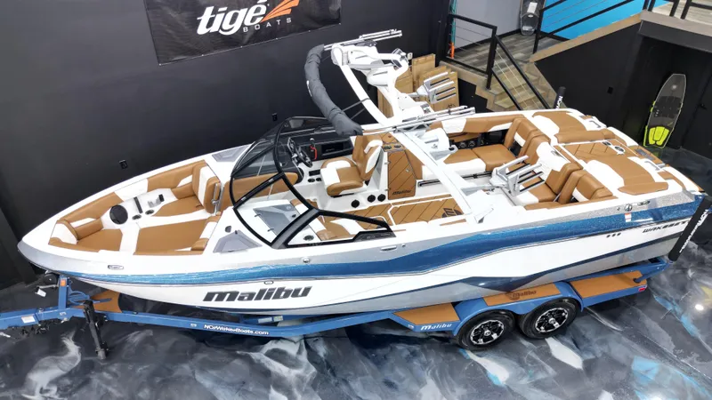 Slide: The Image of 2022 Malibu Wakesetter 25 LSV boat on display in showroom, featuring sleek design and luxury seating. - 7