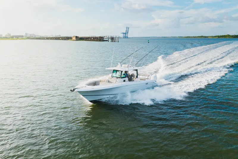 Slide: The Image of 2023 HCB 42 Lujo boat cruising on open water, leaving a wake behind. - 11