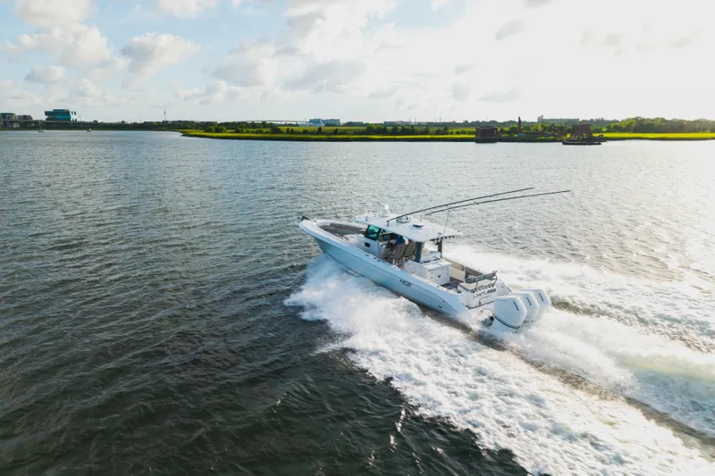 Slide: The Image of 2023 HCB 42 Lujo boat cruising on a sunny day, creating waves in open water. - 12