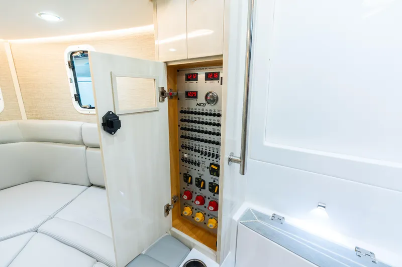 Slide: The Image of 2023 HCB 42 Lujo yacht interior with open electrical panel and seating area. - 23