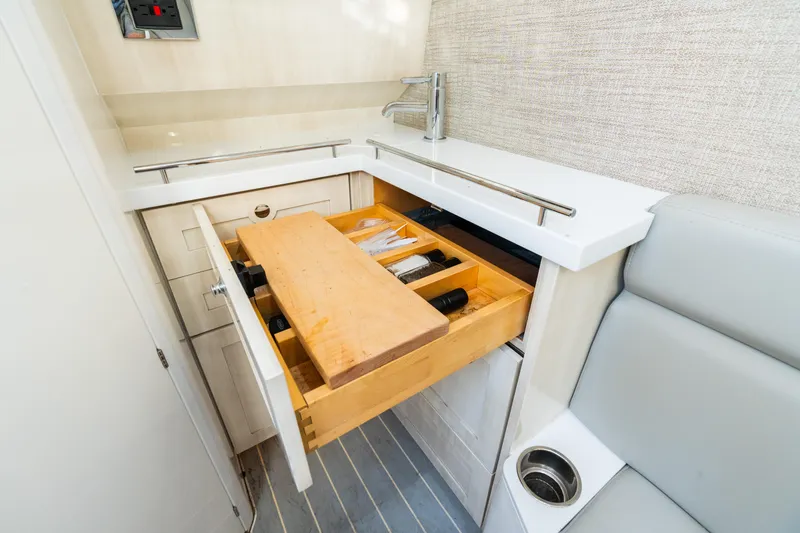 Slide: The Image of 2023 HCB 42 Lujo boat interior with open kitchen drawer and cutting board. - 28