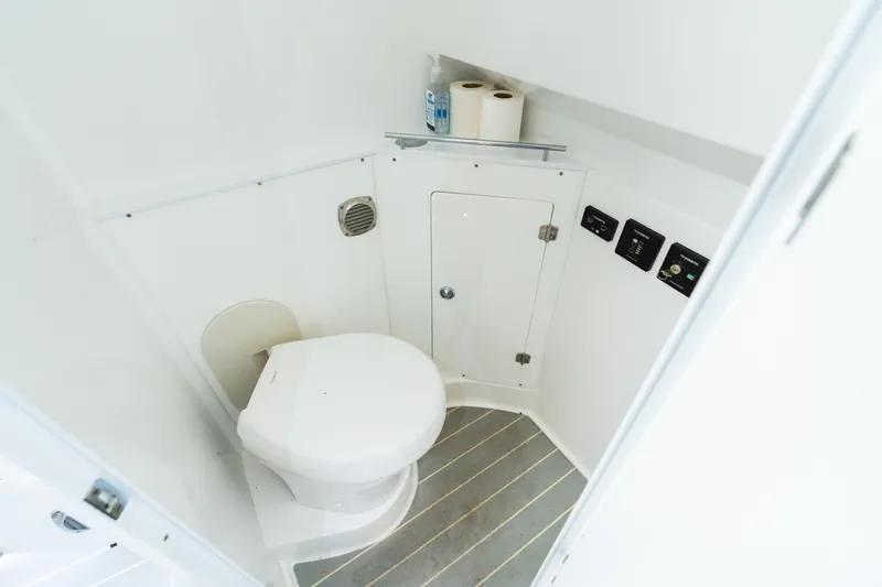 Slide: The Image of 2023 HCB 42 Lujo boat bathroom with toilet, storage, and control panels. - 31