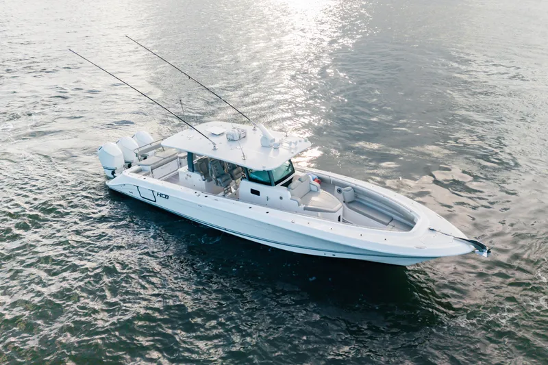 Slide: The Image of 2023 HCB 42 Lujo boat on water, featuring sleek design and multiple outboard engines. - 7