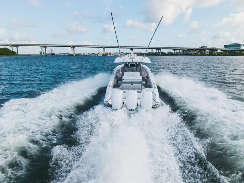 Slide: The Image of 2023 HCB 42 Lujo boat cruising on open water with bridge in background. - 8