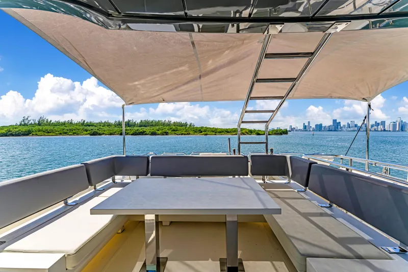 Slide: The Image of Astondoa 80 GLX 2016 yacht deck with seating, table, and canopy, overlooking scenic water view. - 34