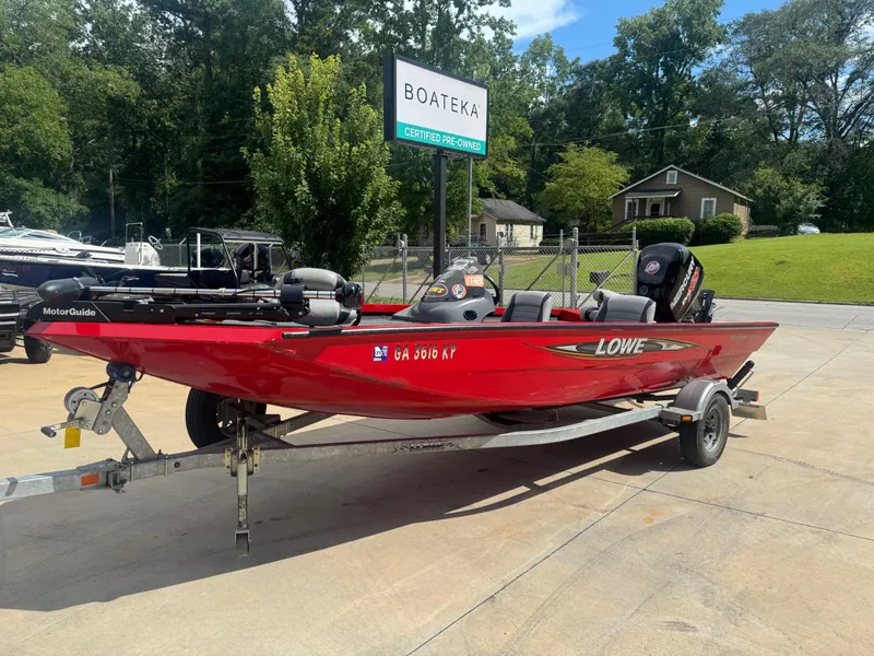 Slide: The Image of Red 2014 Lowe Stinger 18 HP boat on trailer at Boateka dealership. - 1