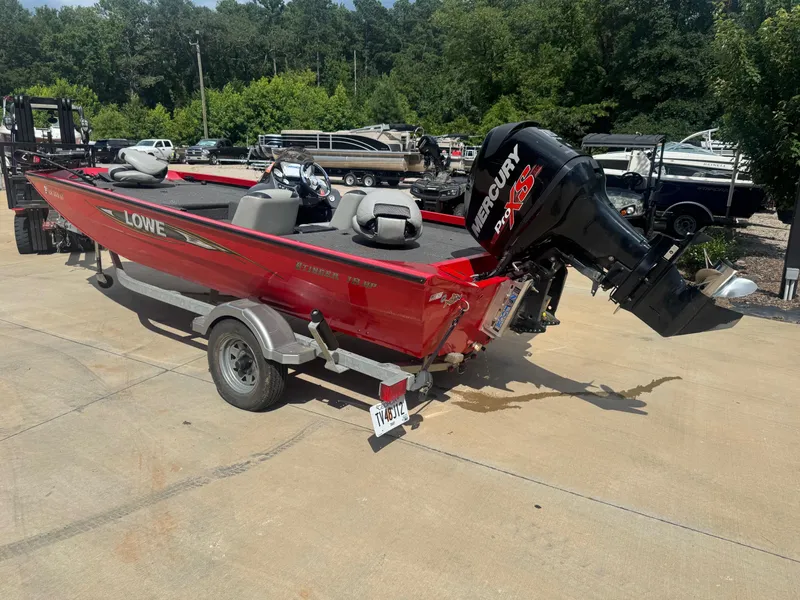 Slide: The Image of 2014 Lowe Stinger 18 HP boat with Mercury engine on trailer, parked outdoors. - 2